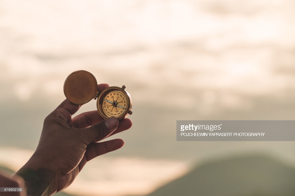 hand golding compass to navigate direction,travel direction discovery